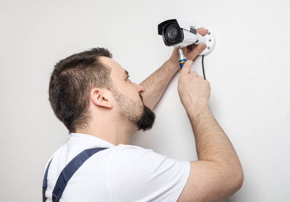 A technician worker installing a video surveillance camera at home.
